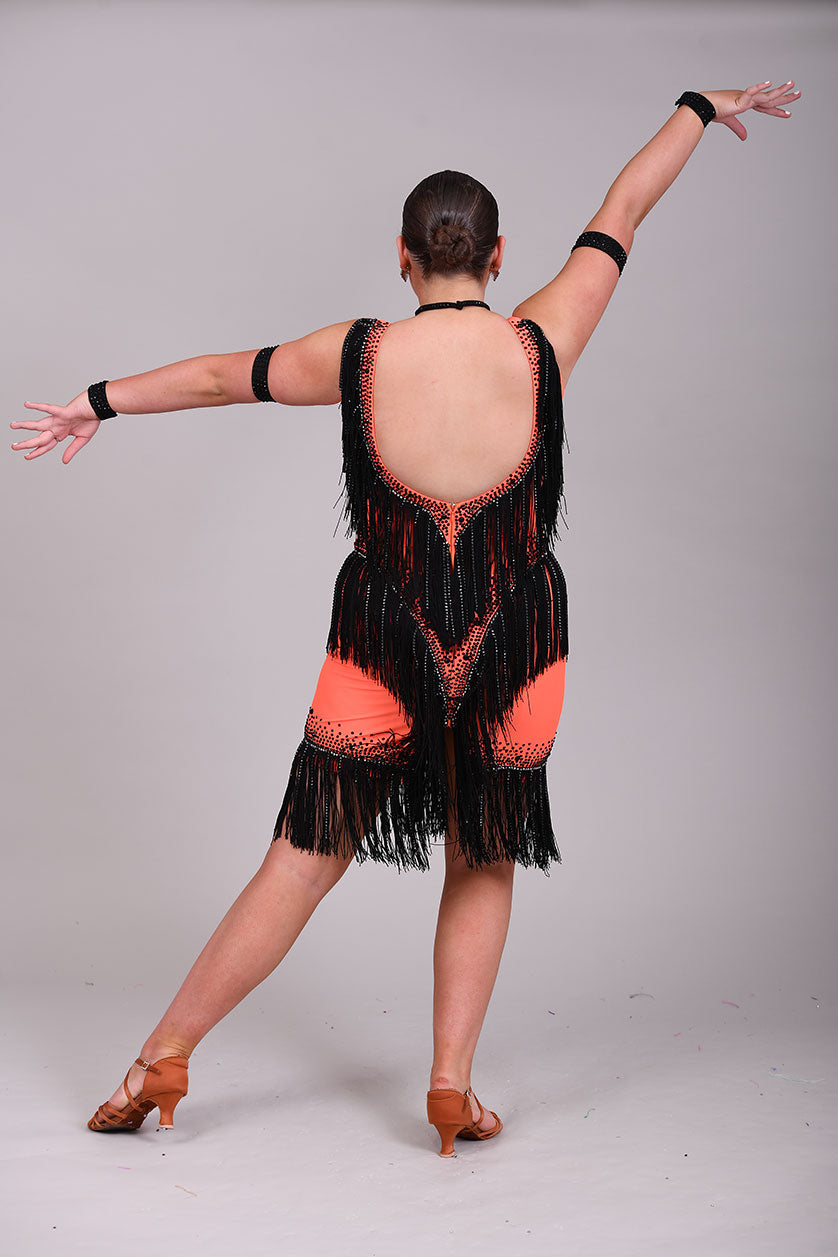 133 Flo Orange Latin dress with black fringe detailing. Plunge neckline. Material droppers stoned in hematite in amongst the fringing. Jet stones.