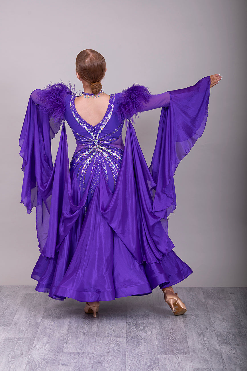 287 Stunning Purple Ballroom Dance Dress. Ostrich feather detail to the upper arm with floaty sleeves from the elbow(finger loop can be added). High back for wearing own bra. Stoned in AB, light Amethyst & Amethyst.
