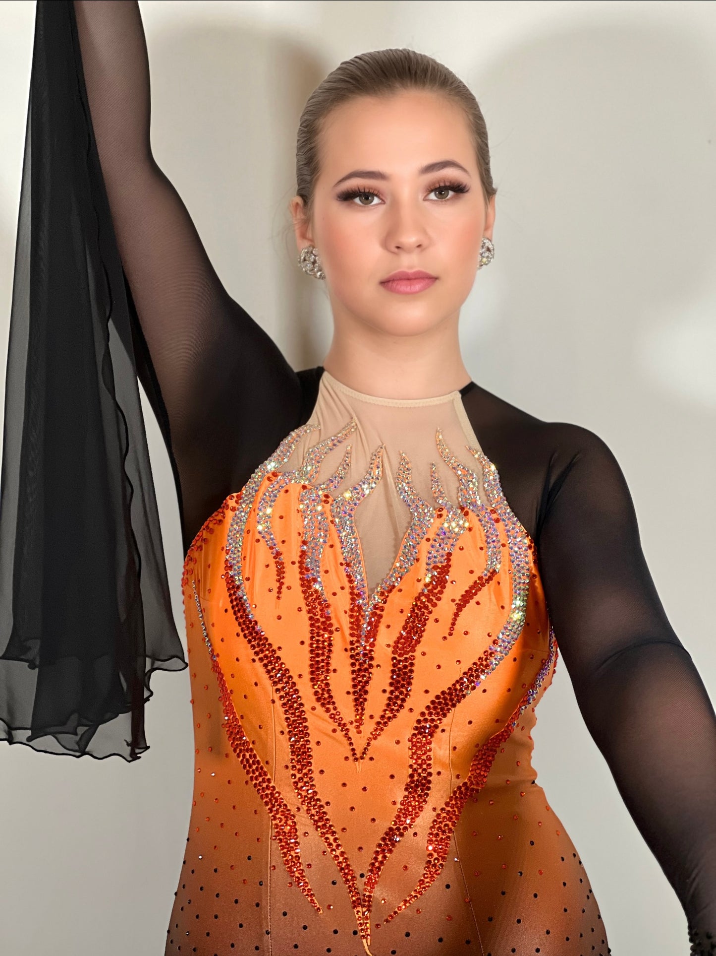 0007 Orange & Black Ombre bodice Ballroom Dress. Keyhole filled in flesh detail to the back with flesh high neck. Detachable floats to the sleeve cuff. Stoned in Siam, Hyacinth & jet.