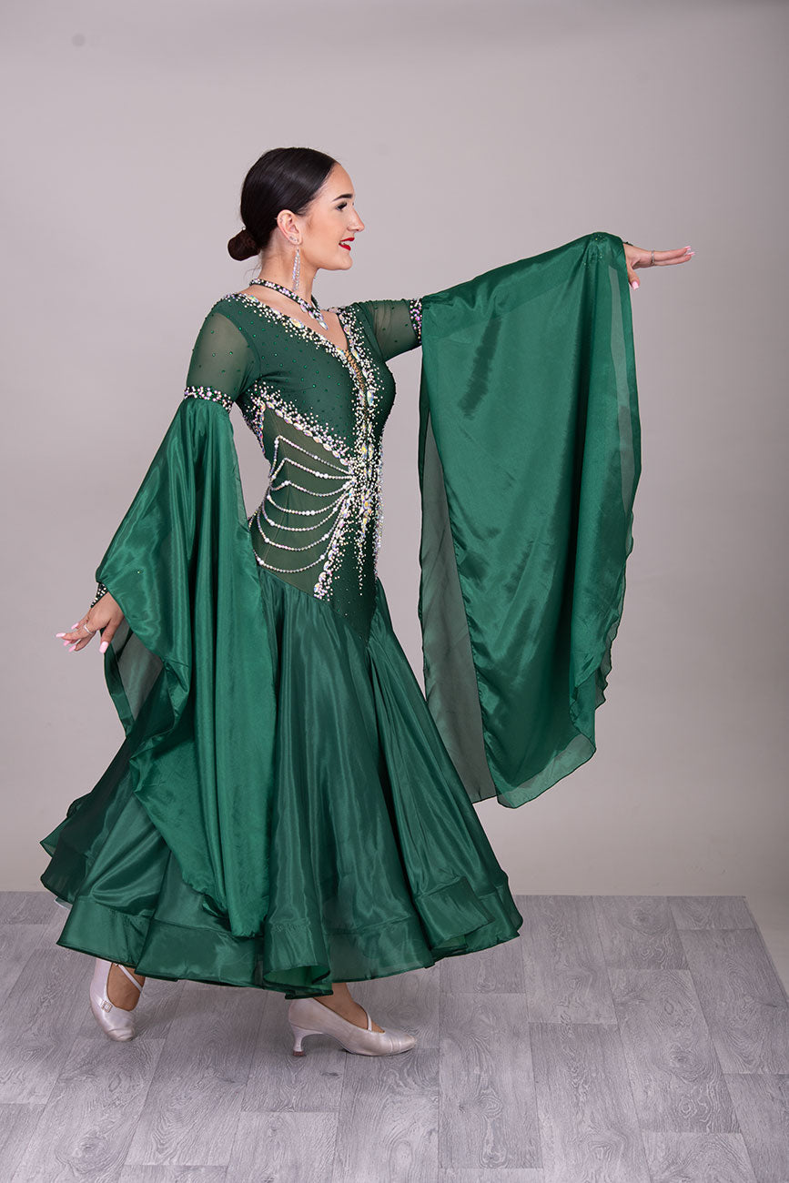 50B TWD “PETITE” Jade Green Competition Ballroom Dance Dress. Beautiful hanging strap detail on the hips. Heavily stoned in AB & Emerald & pearls. Bell sleeves. ❤️Showroom Appointments Available❤️