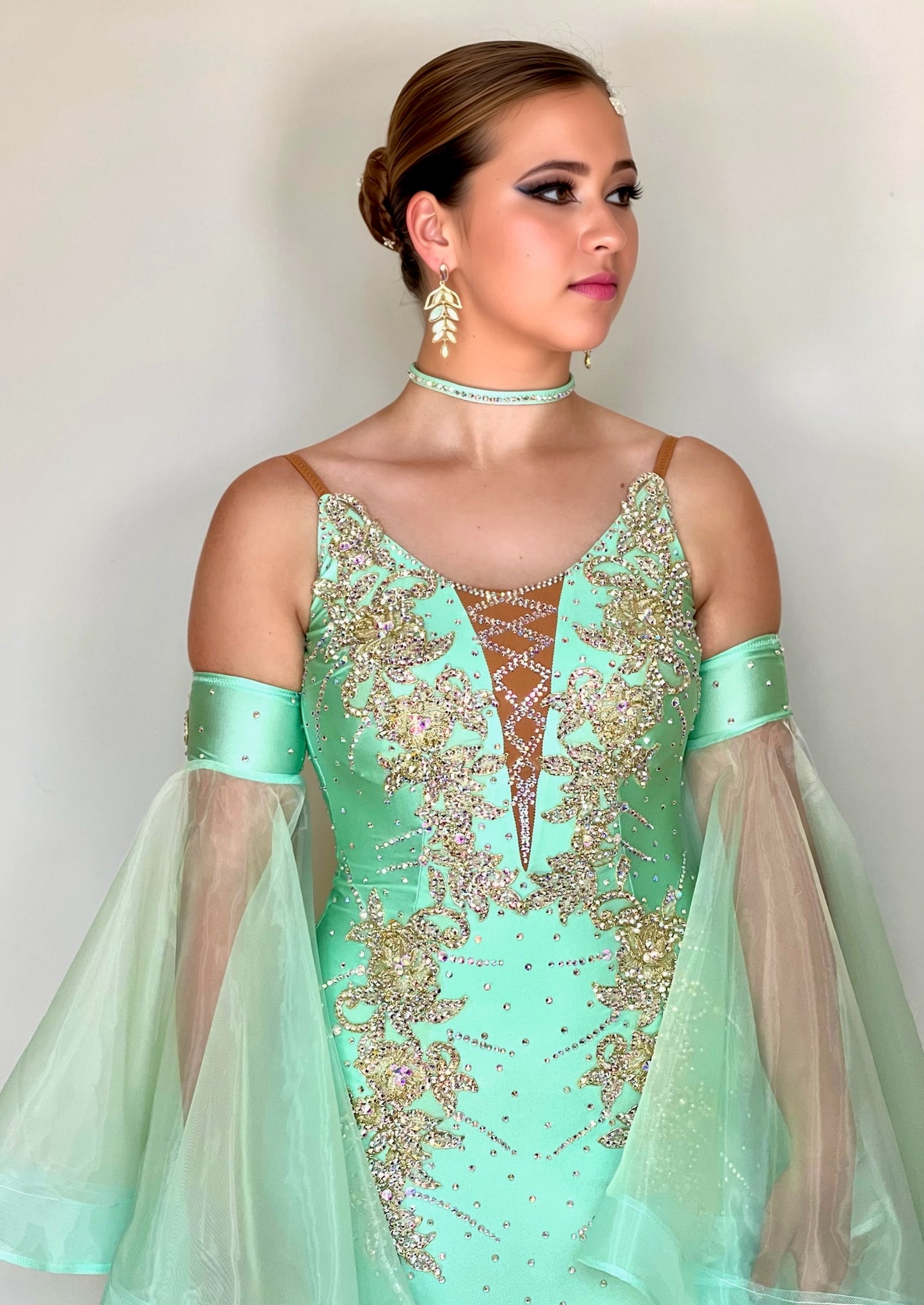 327 mint Green & Gold Ballroom Dress. Decorated with Gold motifs & AB Stones. Comes with separate floaty sleeve cuffs.