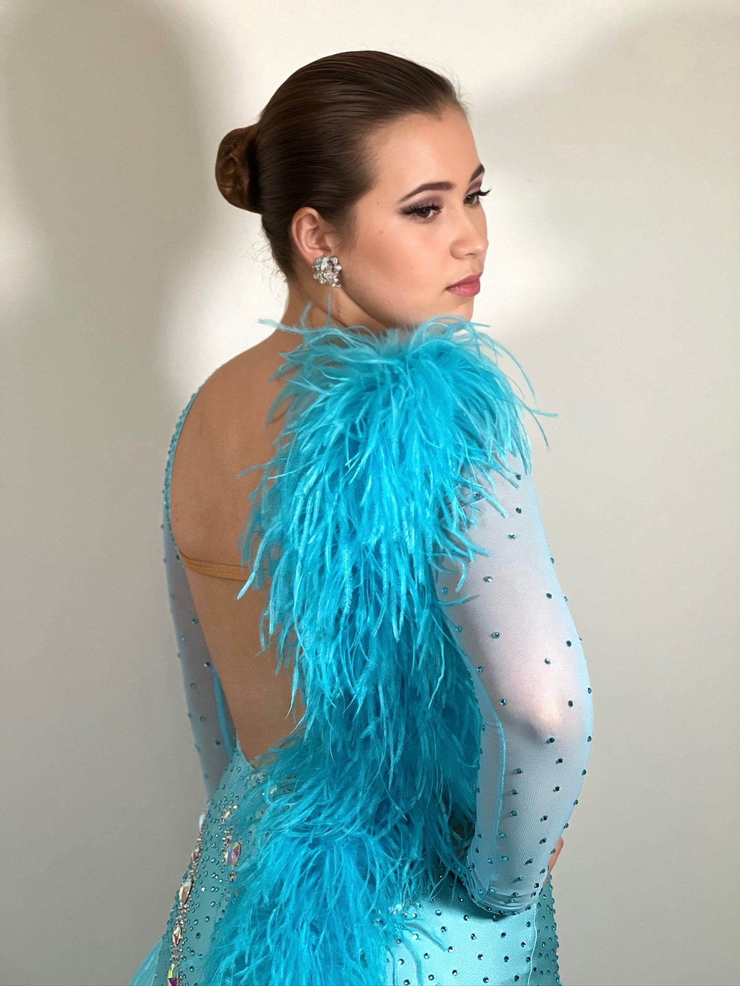 102 Light Paradise Blue Ballroom Dress with Ostrich feather features to the shoulder & back. Stoned in AB with boat neck and low back.