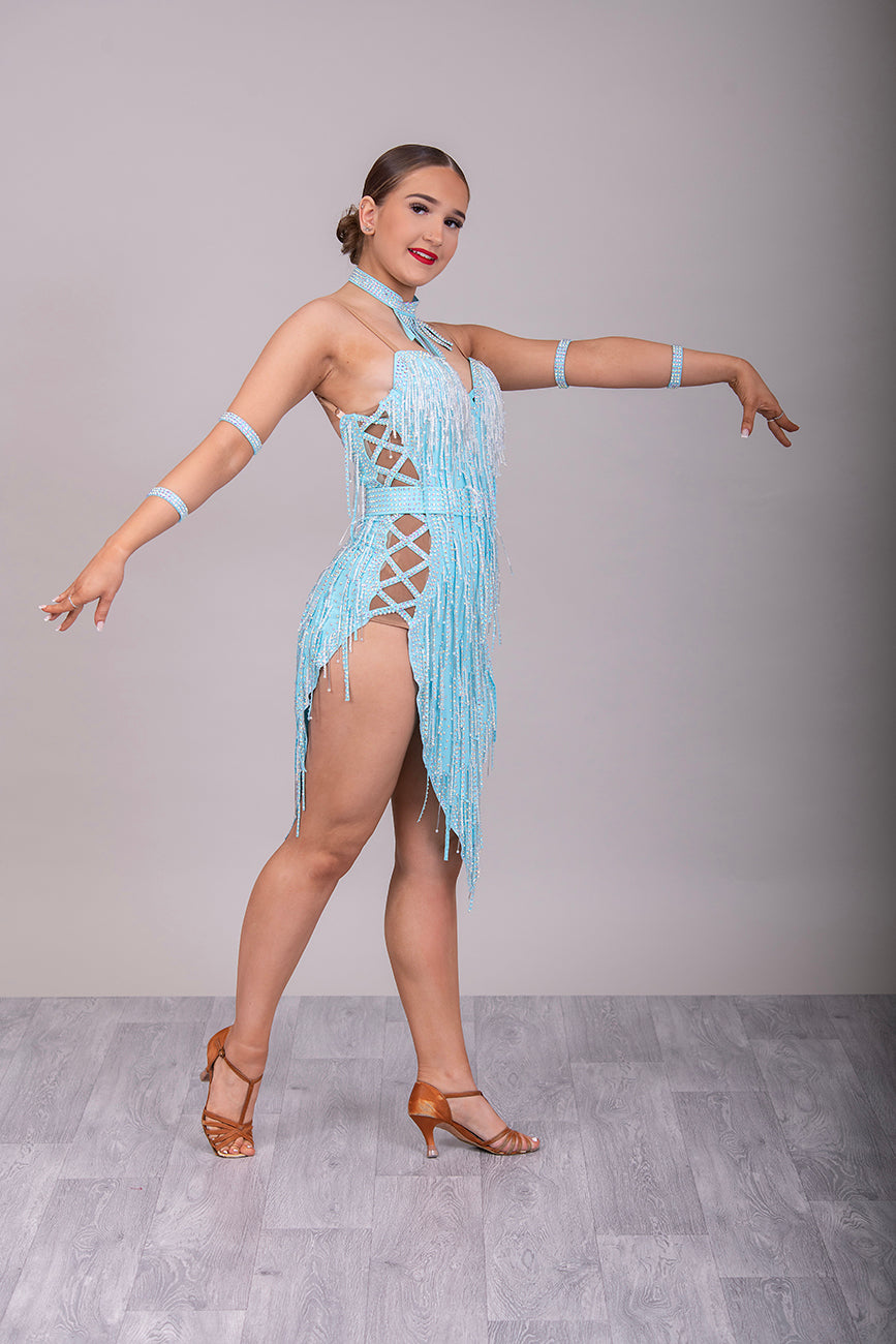 22L Light Aqua Latin/Rhythm Competition Dance Dress. Heavily beaded at the chest & skirts & AB with optional Belt. Bead droppers to the chest area & Skirt with cross detailing to the hips. Necklace & Bracelets included