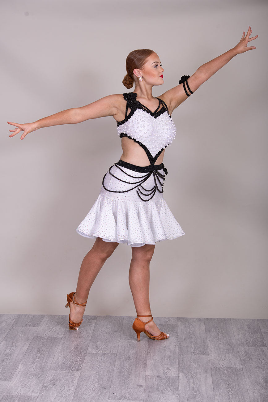 (BUDGET)10 Striking White & Black Competition Latin Dance Dress. Heavily decorated with white pearls & Black bedding all over. Stoned black motif & flower detailing to the hip.