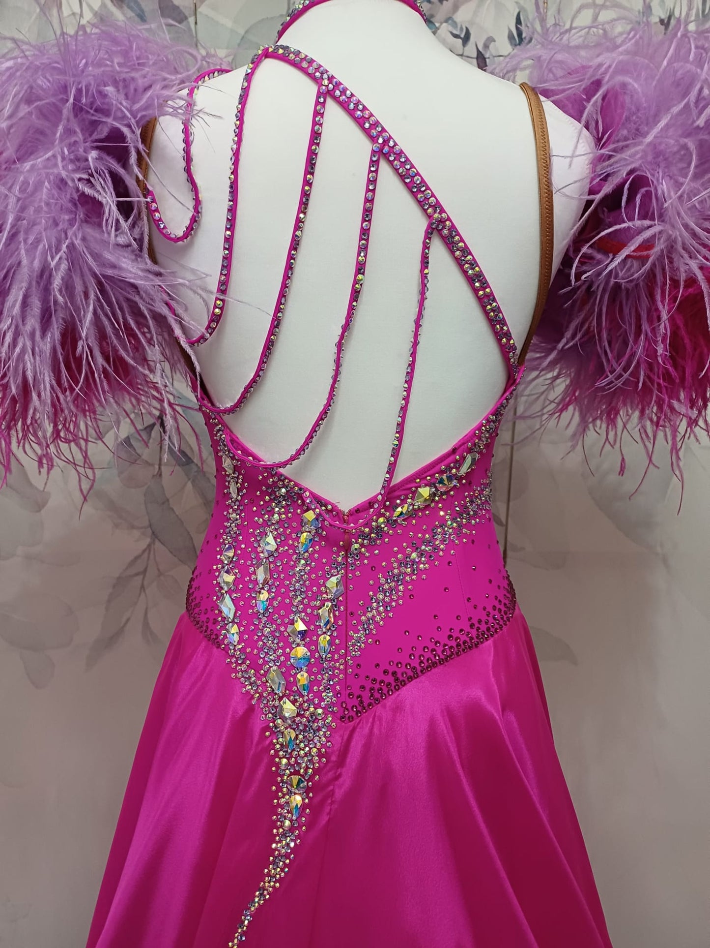 005 Cerise Pink Competition Ballroom Dance Dress. Heavily stoned in AB and Fuchsia & lilac. Comes with ostrich cuffs in Lilac & Cerise. Beautiful back detail.