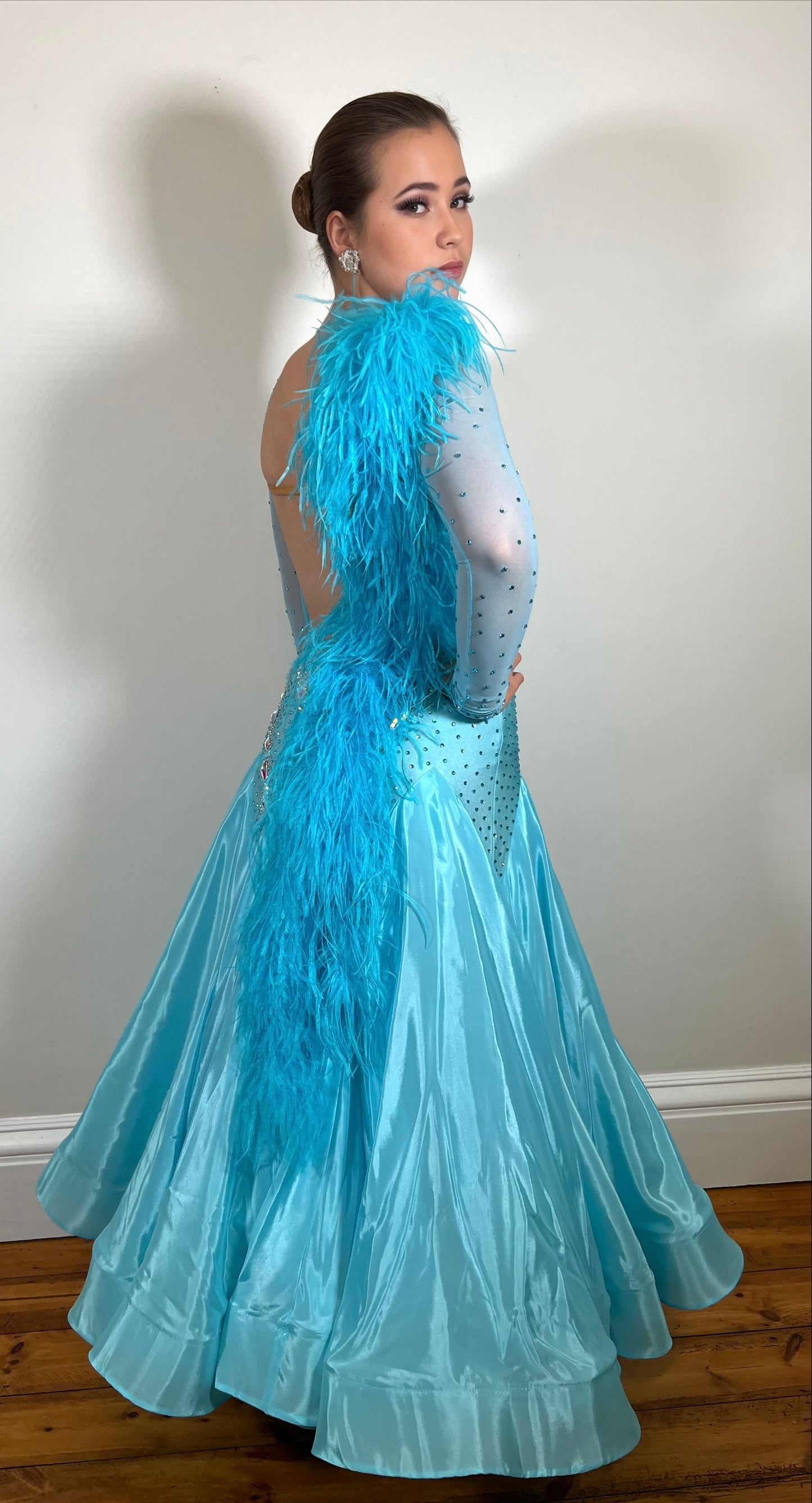 102 Light Paradise Blue Ballroom Dress with Ostrich feather features to the shoulder & back. Stoned in AB with boat neck and low back.