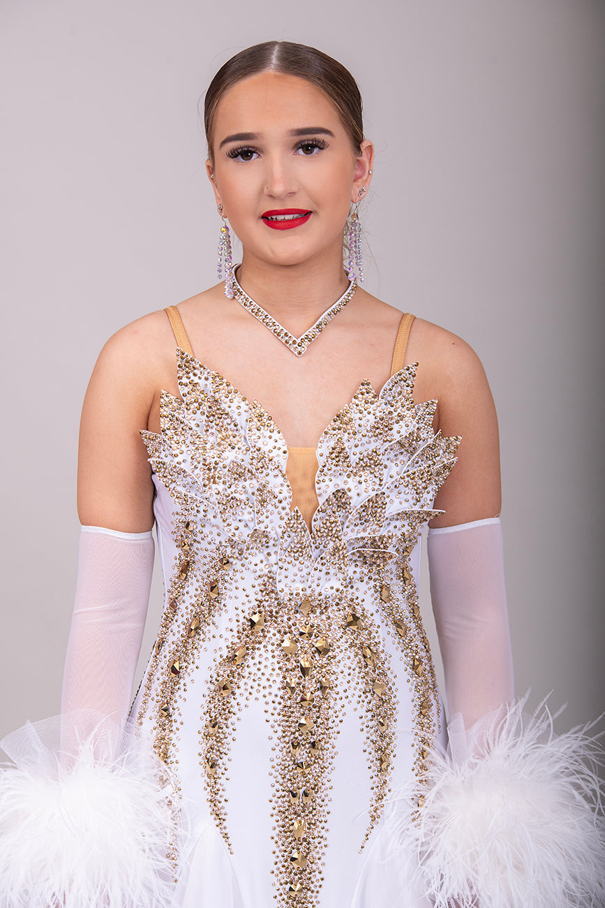 012 Stand out White & Gold Competition Ballroom Dance Dress. 3D design to the Bodice heavily stoned in Gold Ore & Golden Shadow. Detachable Floats with Ostrich feather cuffs.