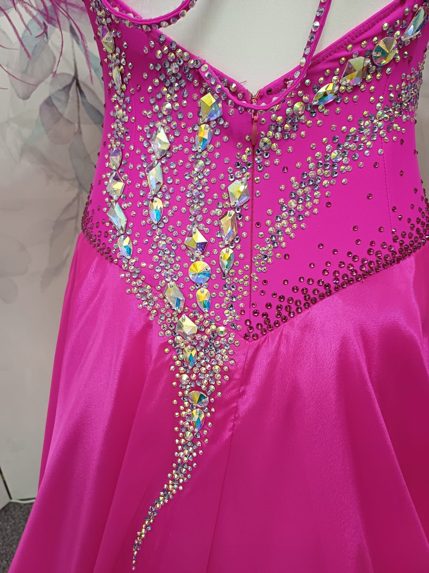 005 Cerise Pink Competition Ballroom Dance Dress. Heavily stoned in AB and Fuchsia & lilac. Comes with ostrich cuffs in Lilac & Cerise. Beautiful back detail.