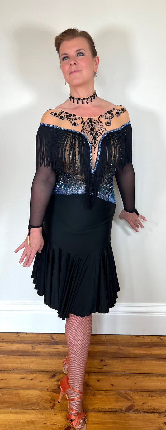 279 Black Competition Latin Dress. Stoned in Sapphire AB & Jet stones. Off the shoulder effect mesh. Black fringe detail to front & back. Full frill skirt giving lovely movement.