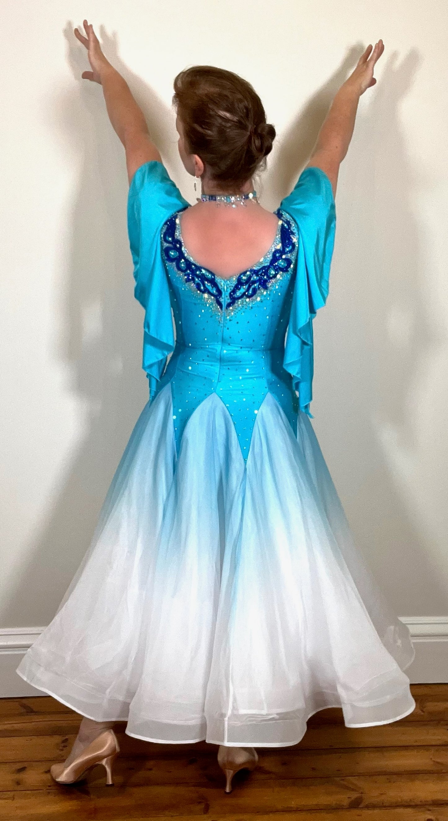 034 Turquoise & White ombré Ballroom Dress. Feature floaty sleeves & flesh panel detail to the chest. Decorated with royal blue motifs. Stoned in sapphire, light sapphire & AB