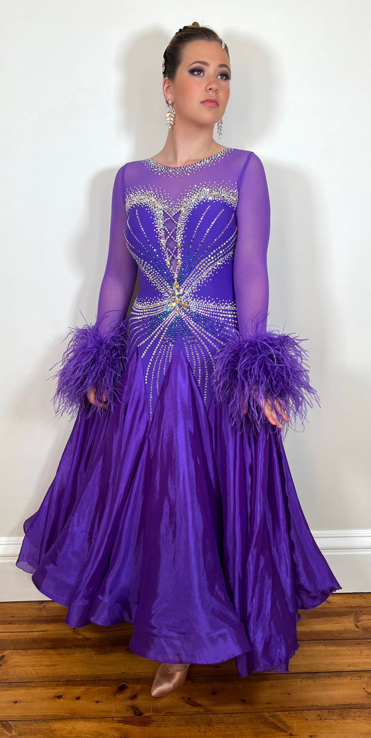 317 Cadbury Purple Competition Ballroom Dress. Heavily stoned on AB with striking detail to the chest. Comes with detachable ostrich feather cuff floats