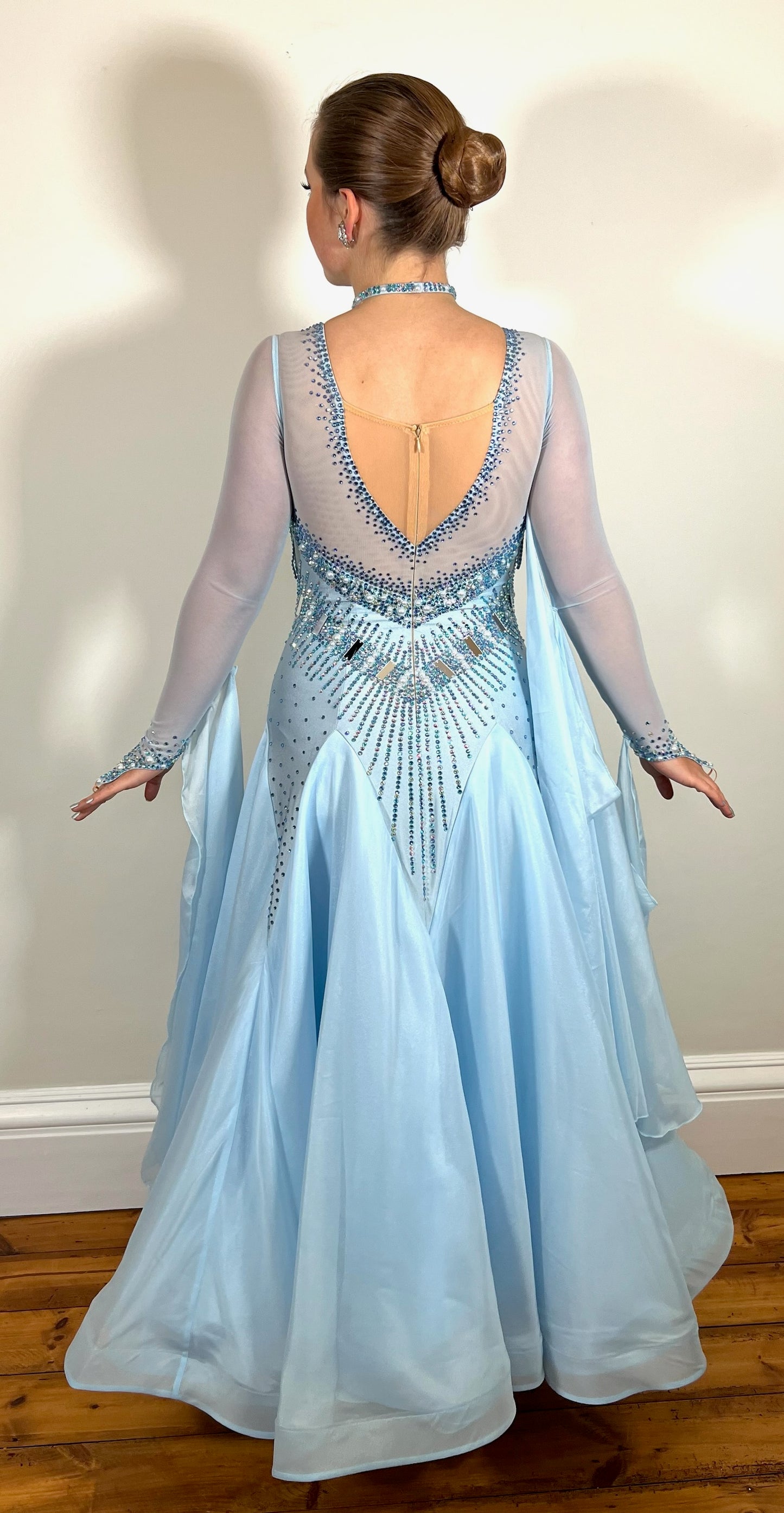 208 Baby Blue boat neck Ballroom Dress with flesh panel to the back. Stoned fringe detail to the chest area. Stoned waist detail to the front & back. Boat neck with flesh panel to the back. Decorated with AB, light sapphire & sapphire stones