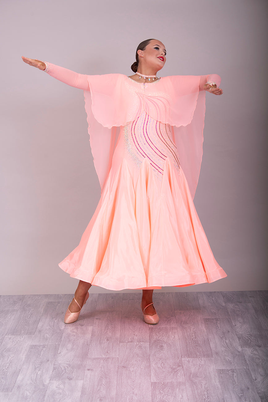 15B Peach Ballroom/Sequence Competition Dance Dress. Beautifully decorated in Peach, Peach AB & AB. Cape effect to the front flowing into floats attached at the shoulders.