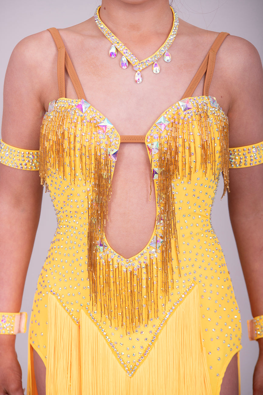 260 Yellow Fringe detailed skirt Latin Dress. AB stones with golden droppers to the chest. Open detailing to the front.