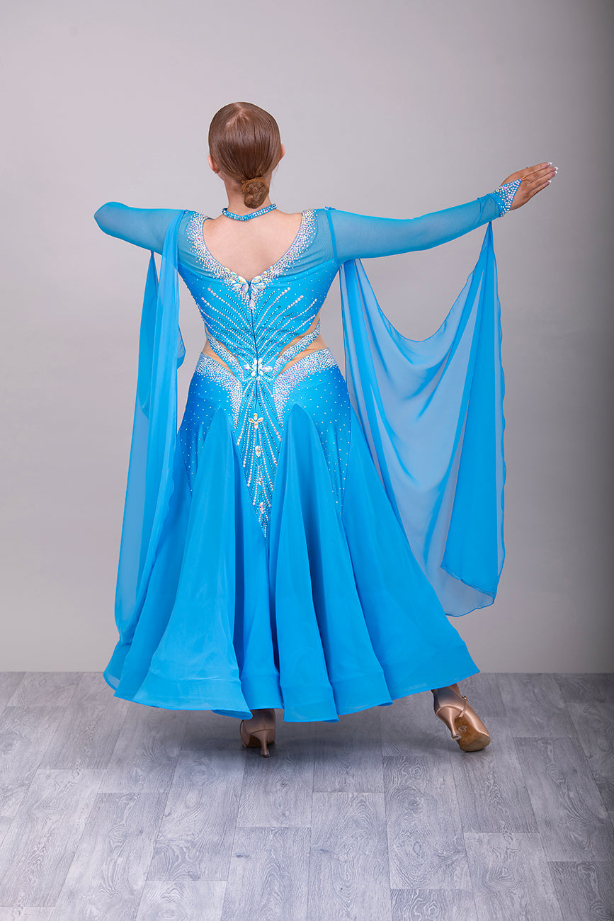094 Turquoise Competition Ballroom Dance Dress heavily decorated heavily decorated with AB & Capri Blue Stones. Flattering stoned strap detailing detailing to the waist area. High back to give option to wear own bra. Detachable floats