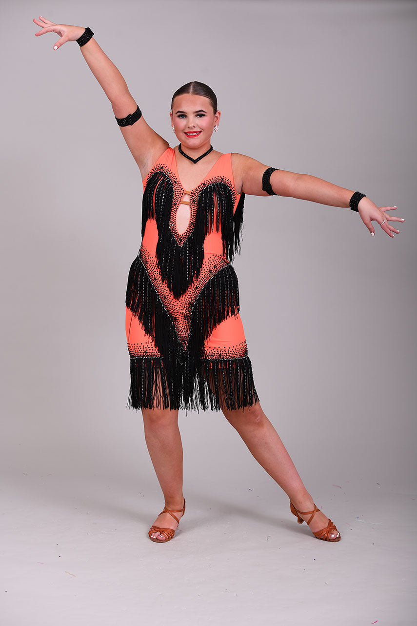 133 Flo Orange Latin dress with black fringe detailing. Plunge neckline. Material droppers stoned in hematite in amongst the fringing. Jet stones.
