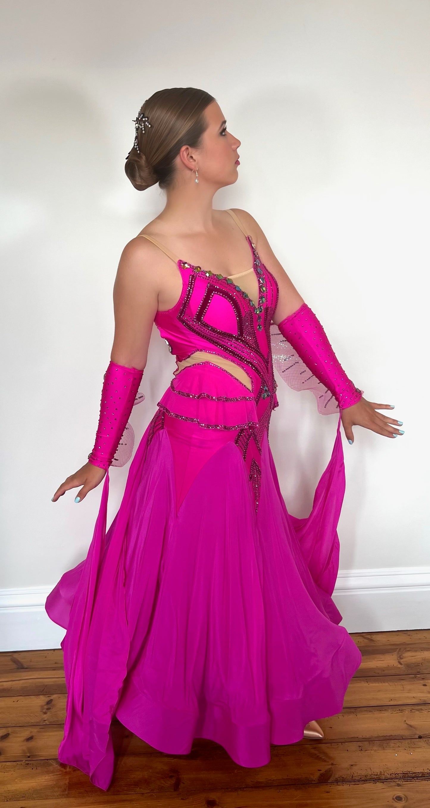 211 Magenta Pink Ballroom Dress. Flesh detailed panelling throughout bodice. Gloveless with organza detail & floats. Stoned in magenta