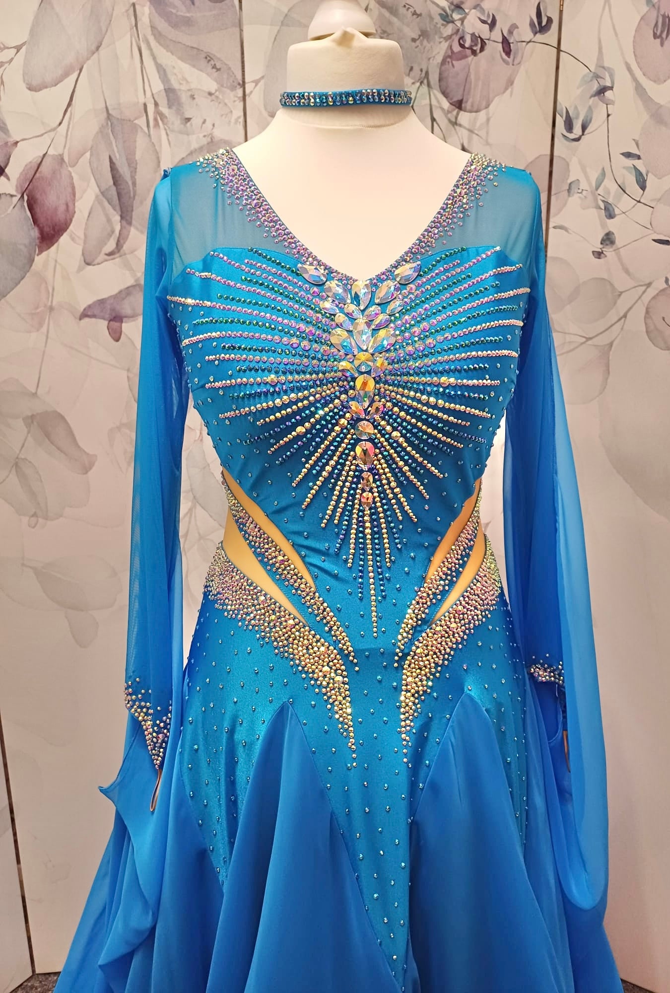 094 Turquoise Competition Ballroom Dance Dress heavily decorated heavily decorated with AB & Capri Blue Stones. Flattering stoned strap detailing detailing to the waist area. High back to give option to wear own bra. Detachable floats