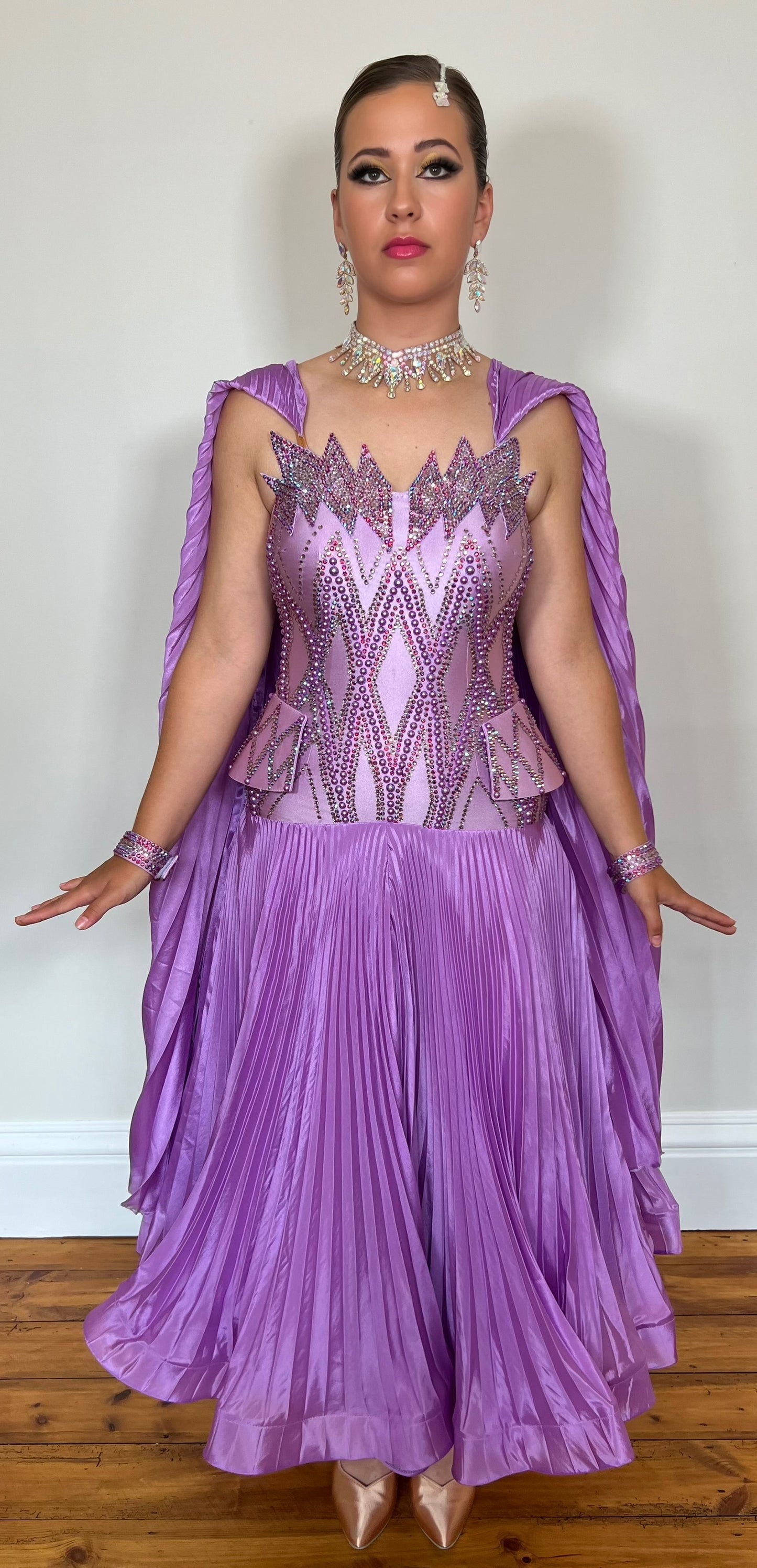 046 Violet Pleated skirt & Shoulder floats Ballroom Dress. Stunning Bodice detail with hip detailing. Decorated with violet pearls, AB & fuchsia stones. Pleated should floats