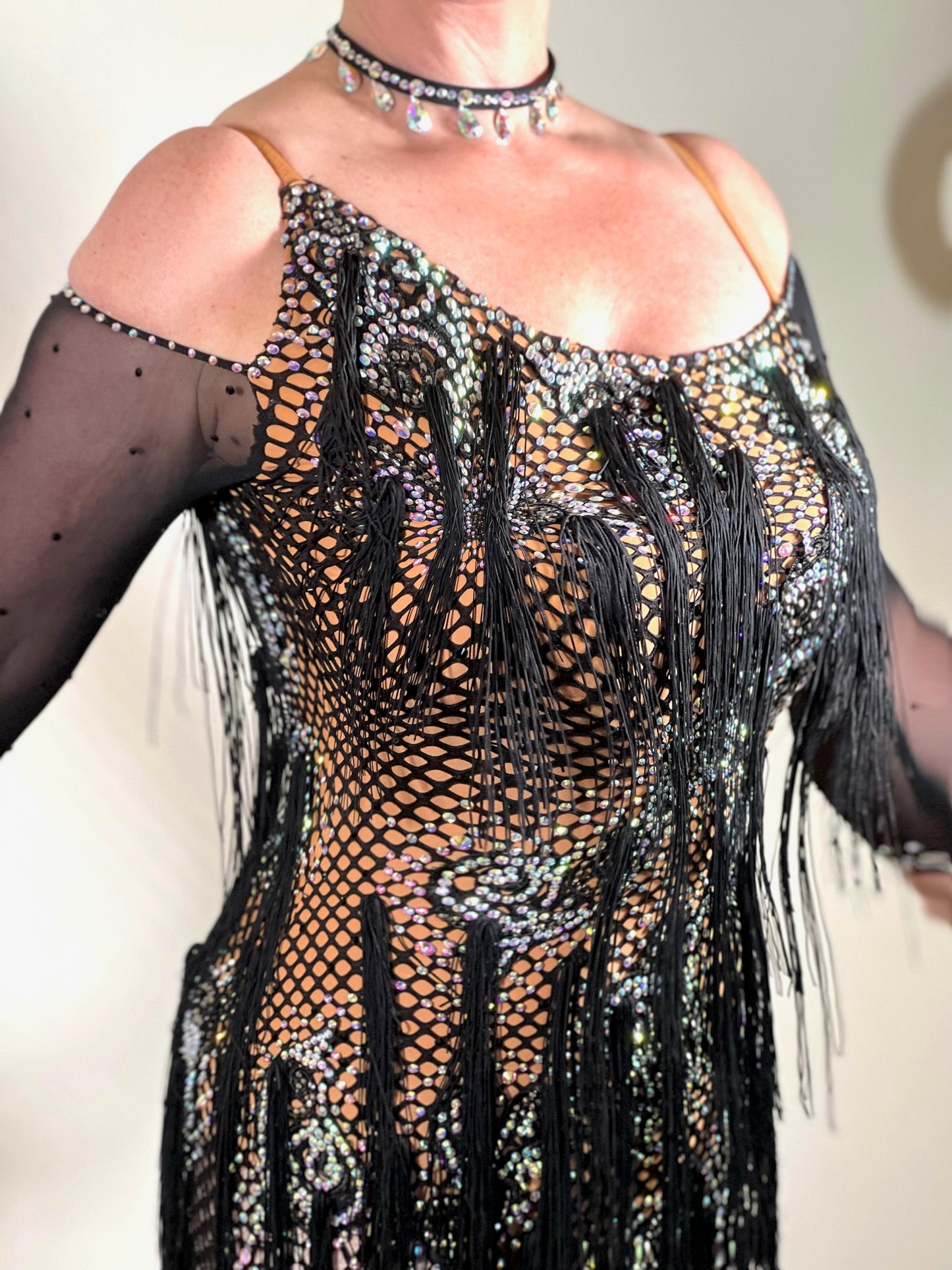 068 Black & Tan Wide fishnet Competition Latin Dress. Hanging fringe all over. Heavily stoned in crystal golden shadow, topaz & AB. Cold shoulder detailing to one arm, full shoulder to other arm