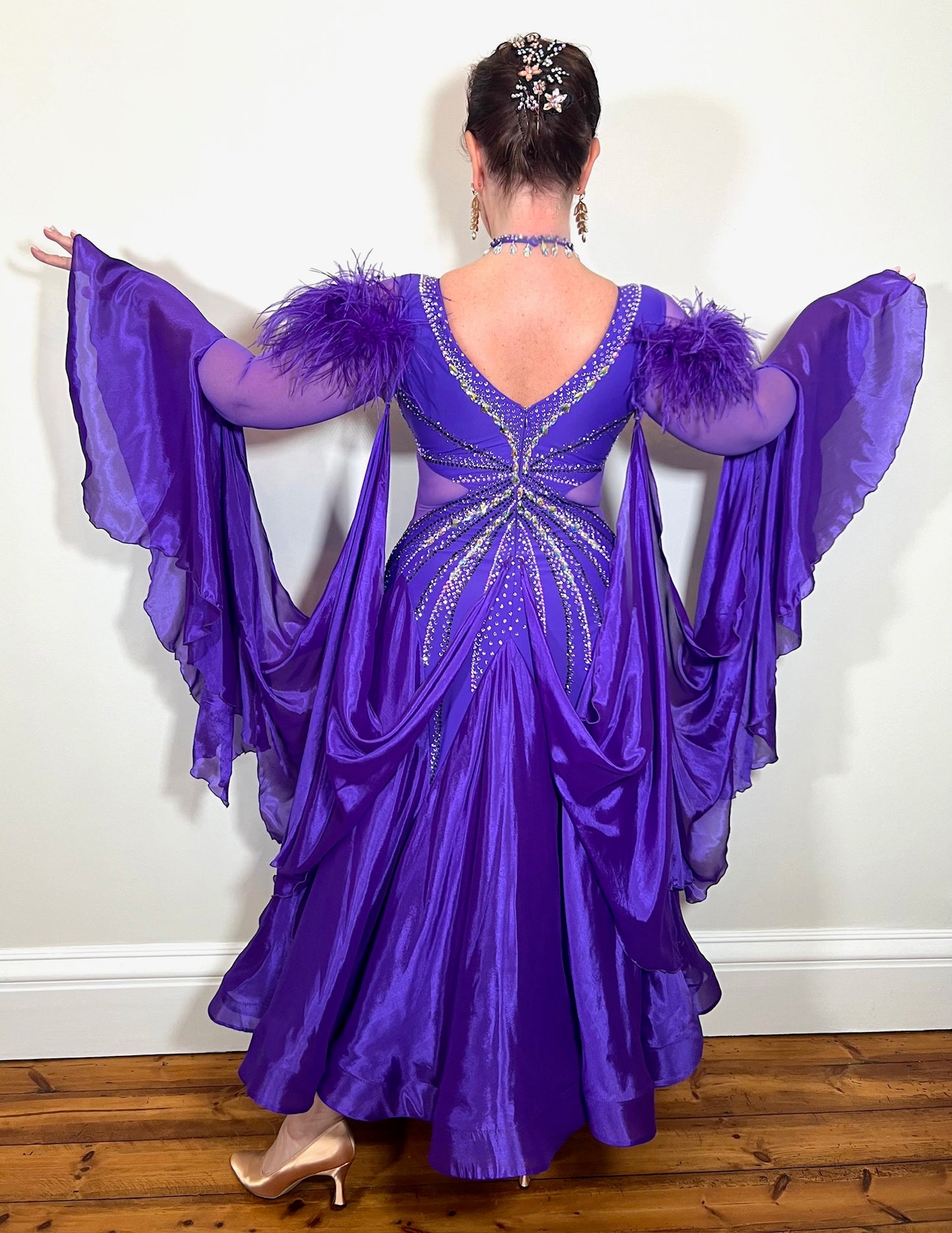 287 Stunning Purple Ballroom Dance Dress. Ostrich feather detail to the upper arm with floaty sleeves from the elbow(finger loop can be added). High back for wearing own bra. Stoned in AB, light Amethyst & Amethyst.