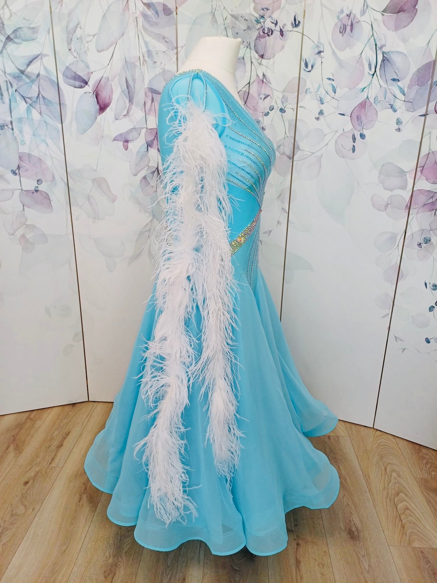 277 Beautiful Ice Blue Competition Ballroom Dance Dress. Stones in AB. Comes with Ostrich feather boa floats. These can be blue & white or a mix of the 2 colours. High back to all for wearing own bra.