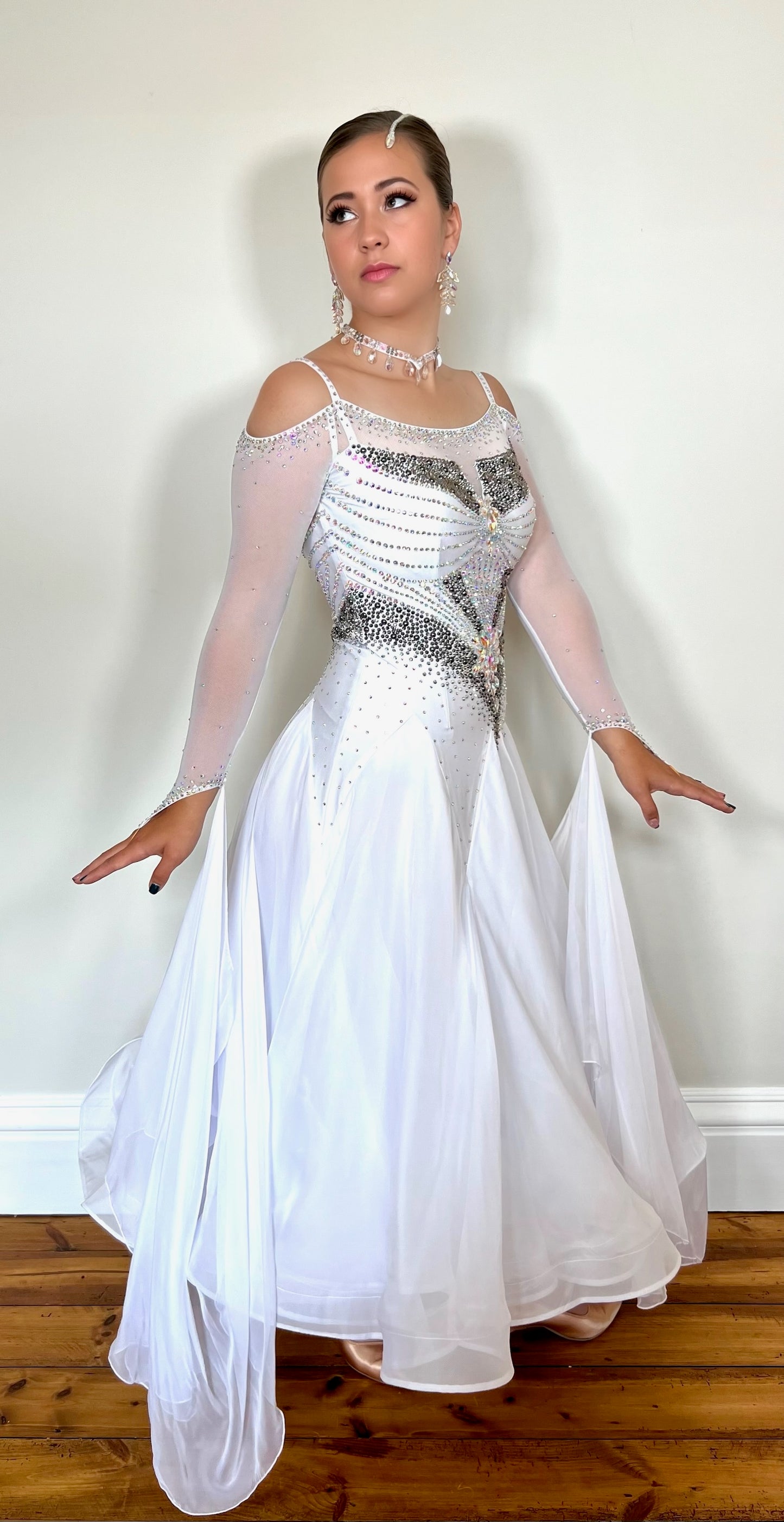325 white Ballroom Dress decorated with Silver & AB stones. Strapping detail to the back & cold shoulder sleeves. Floats to the wrist.