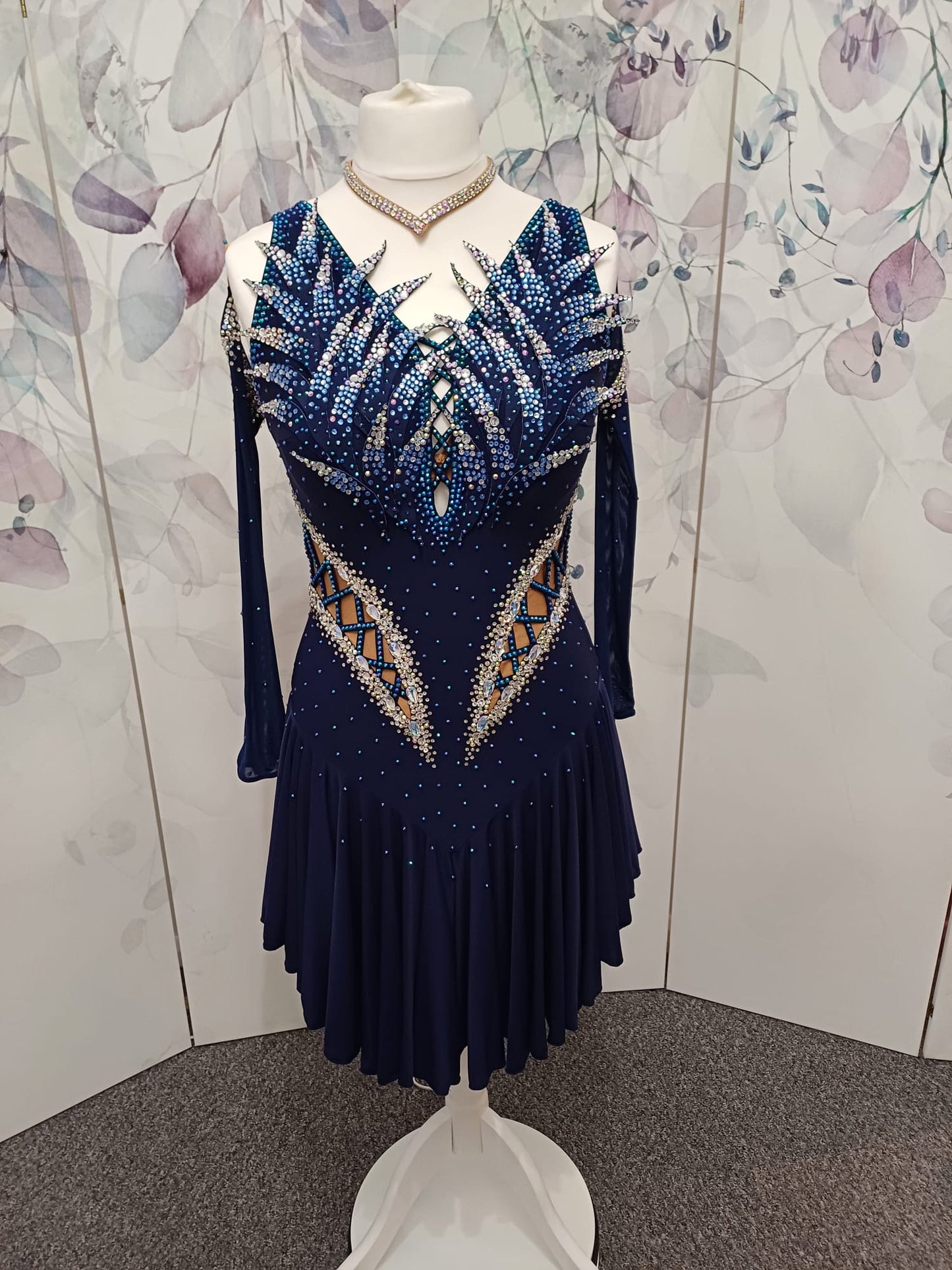 12L Navy Blue Competition Latin/Rhythm Dress. 3D Design to upper chest with flattering detailing to Hips. High back giving option to wear own Bra. Stoned in Blue, Blue AB & AB