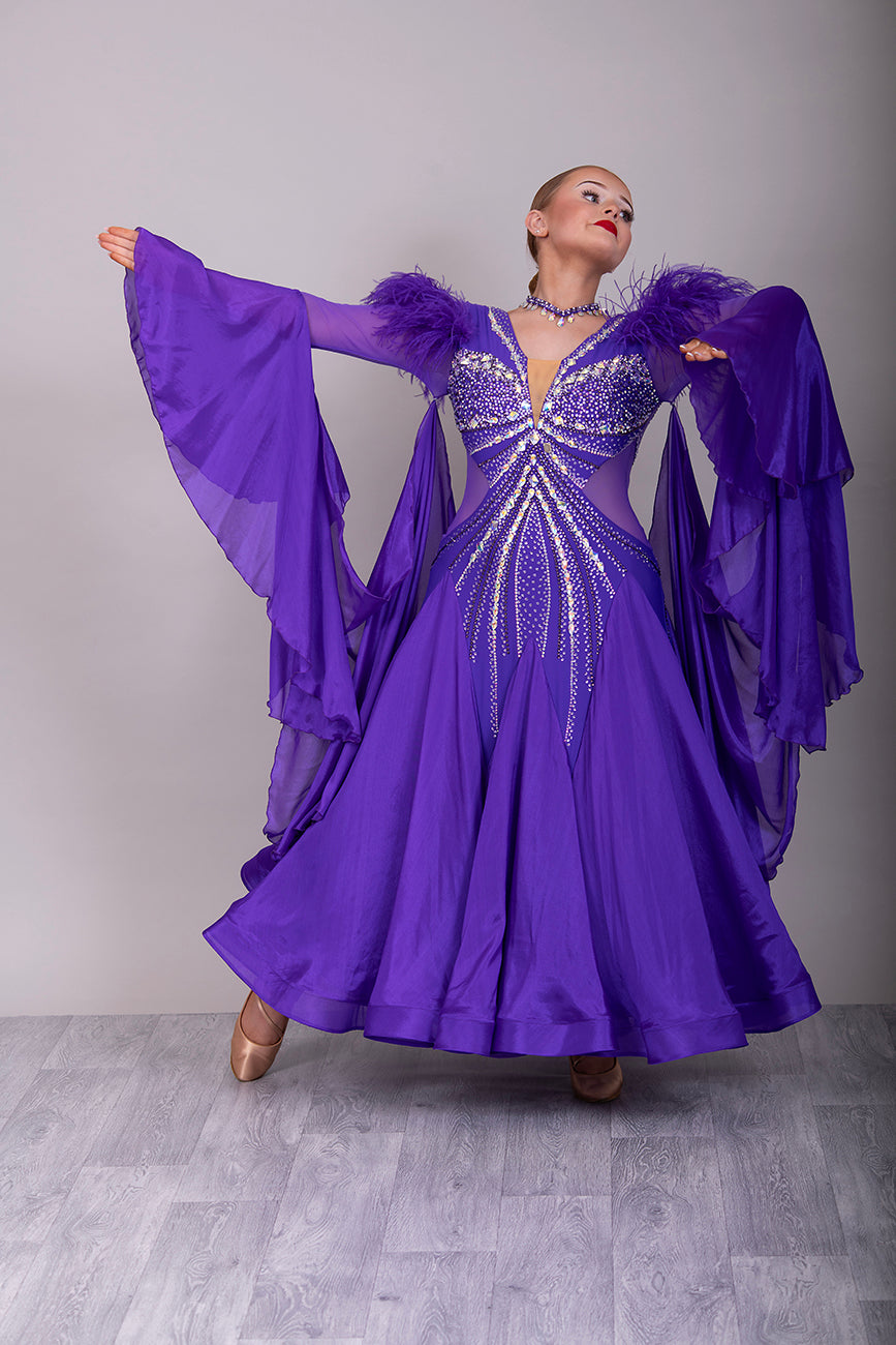 287 Stunning Purple Ballroom Dance Dress. Ostrich feather detail to the upper arm with floaty sleeves from the elbow(finger loop can be added). High back for wearing own bra. Stoned in AB, light Amethyst & Amethyst.