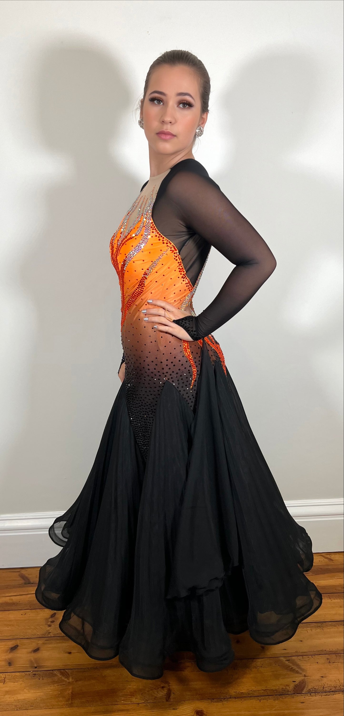 0007 Orange & Black Ombre bodice Ballroom Dress. Keyhole filled in flesh detail to the back with flesh high neck. Detachable floats to the sleeve cuff. Stoned in Siam, Hyacinth & jet.
