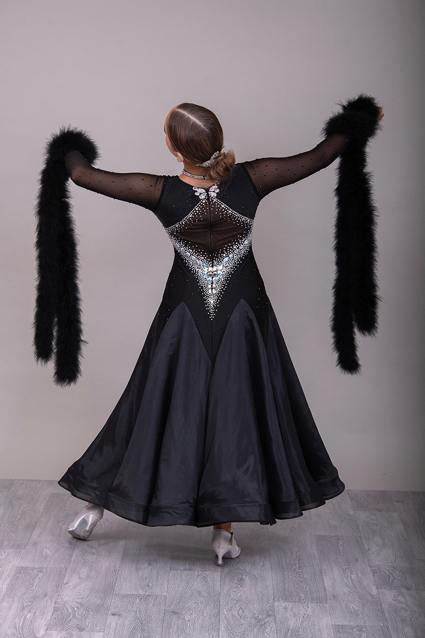 324 Black Ballroom Dress with feather floats to the wrist. Rouched detail to the chest area. Heavily decorated stoning to the front & back in AB. High back.