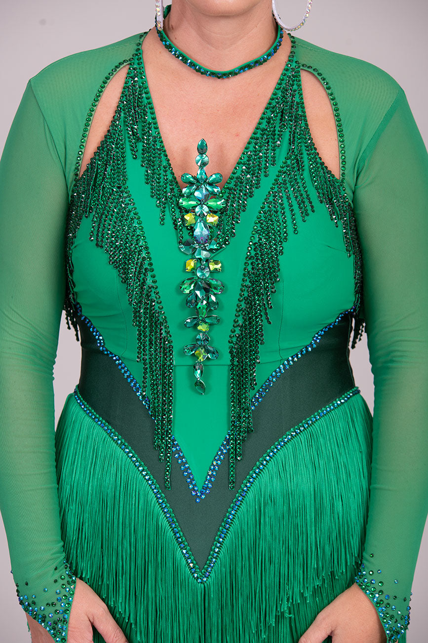 114L Deep Green Competition Latin Dance dress. Stunning Stone detail to the Front with open Detailing on the shoulder. Very Full fringed skirt