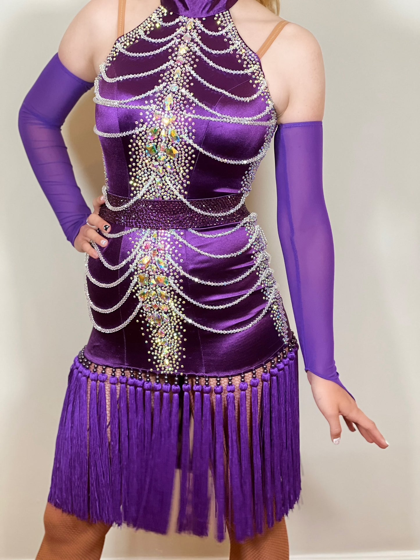 101 Purple Velvet Fringe Skirt Latin Dress. Beaded decorations to front & back of bodice. Stoned in AB with detachable belt. Clumped fringe skirt. Long purple mesh gloves.