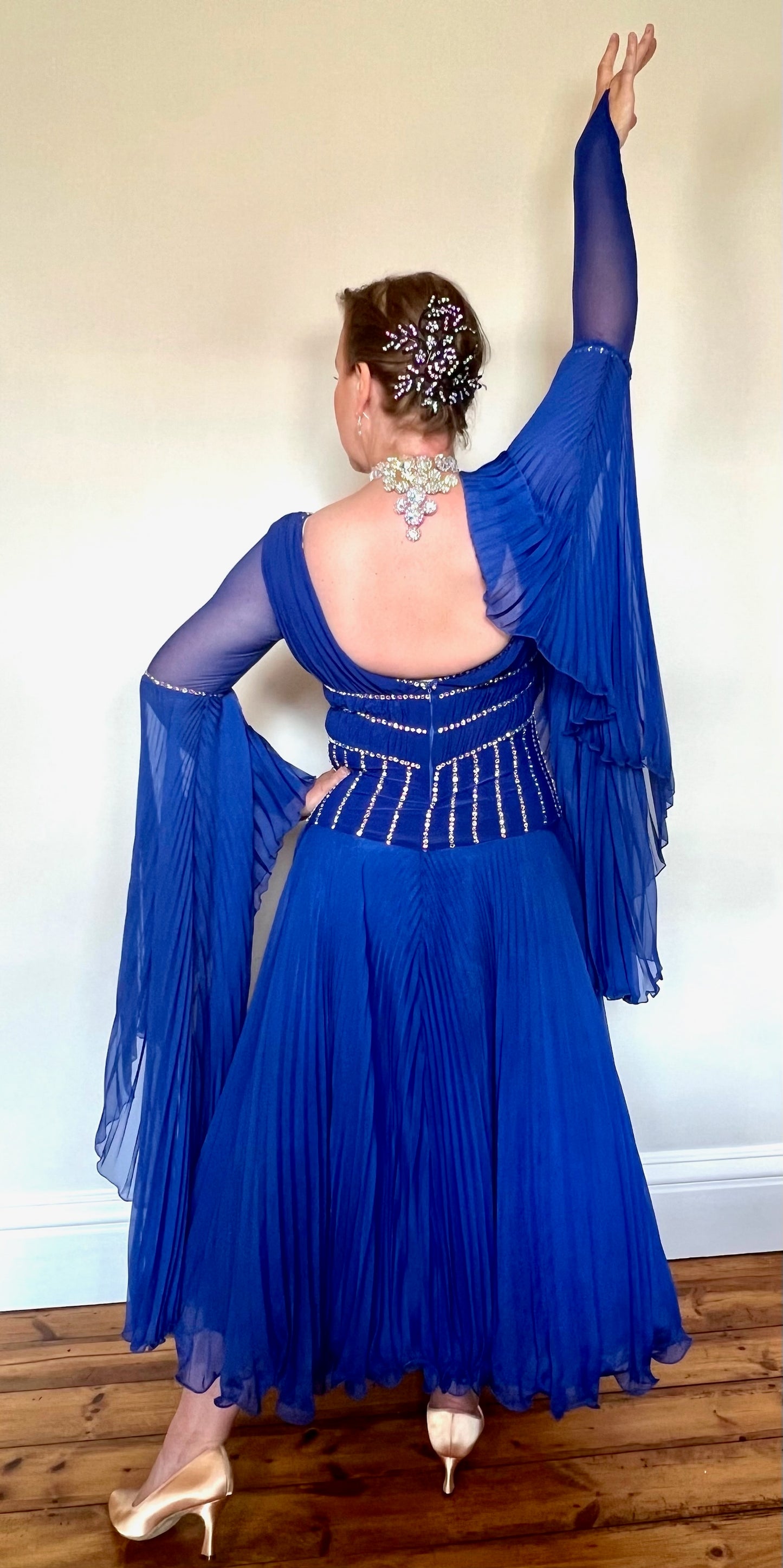 187 Royal Blue Pleated Skirt Ballroom Dress. Full circle pleated cuff detail. Mesh sleeves. Plunge detail bodice with flesh panel. All stones in AB