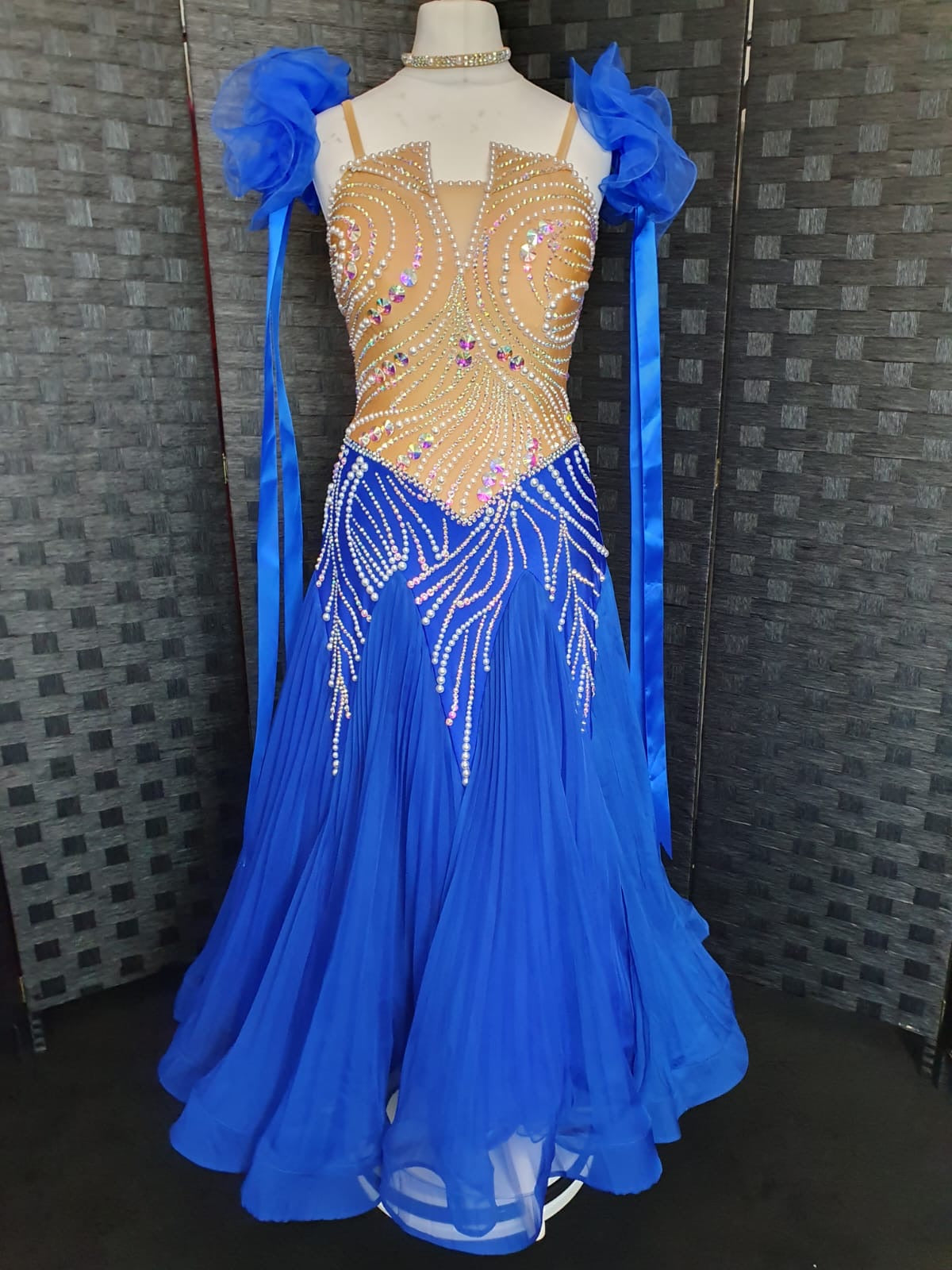 243 Royal Blue & Flesh Ballroom Dress. Decorated in pearls & AB stones. Organza ruffle floats with hanging ribbons.