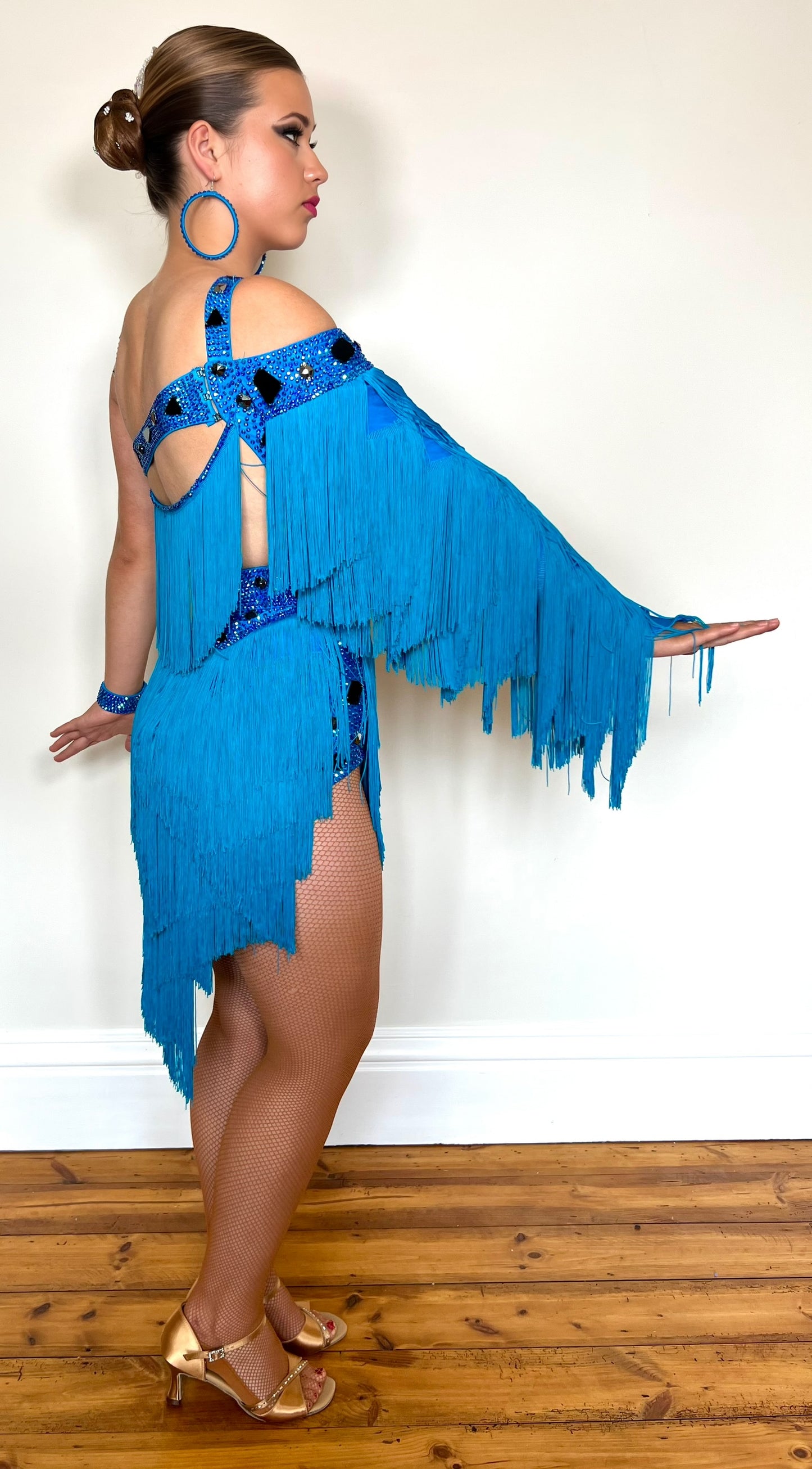 310 Statement Turquoise Latin Dress. Fringed one arm dress with strapping details decorated with Turquoise stones.