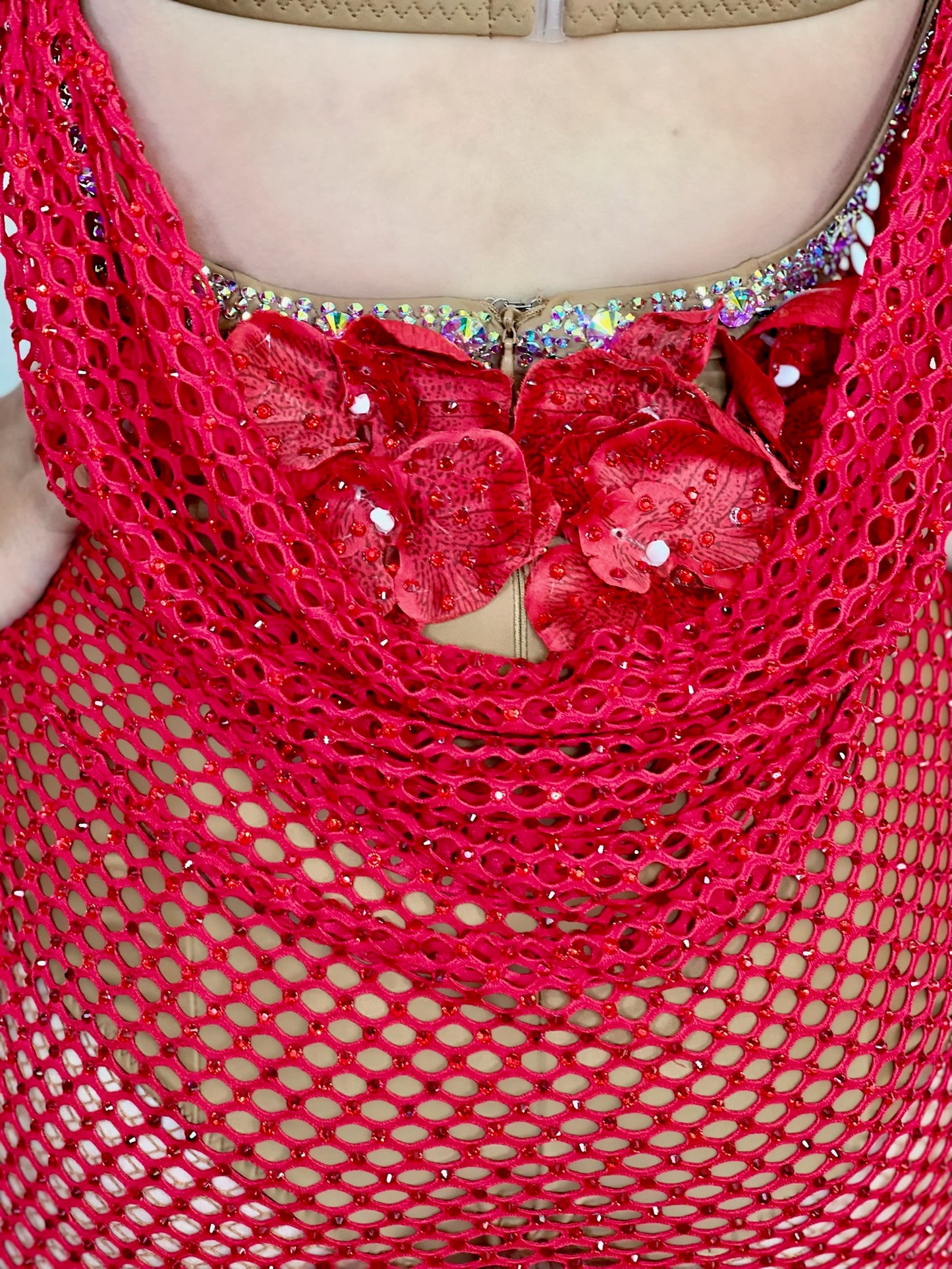 142 Red Latin dress with wide gauge fishnet overlay. Fishnet stoned in Siam. Flesh strapping detail to one hip. Tan leotard decorated in AB stones