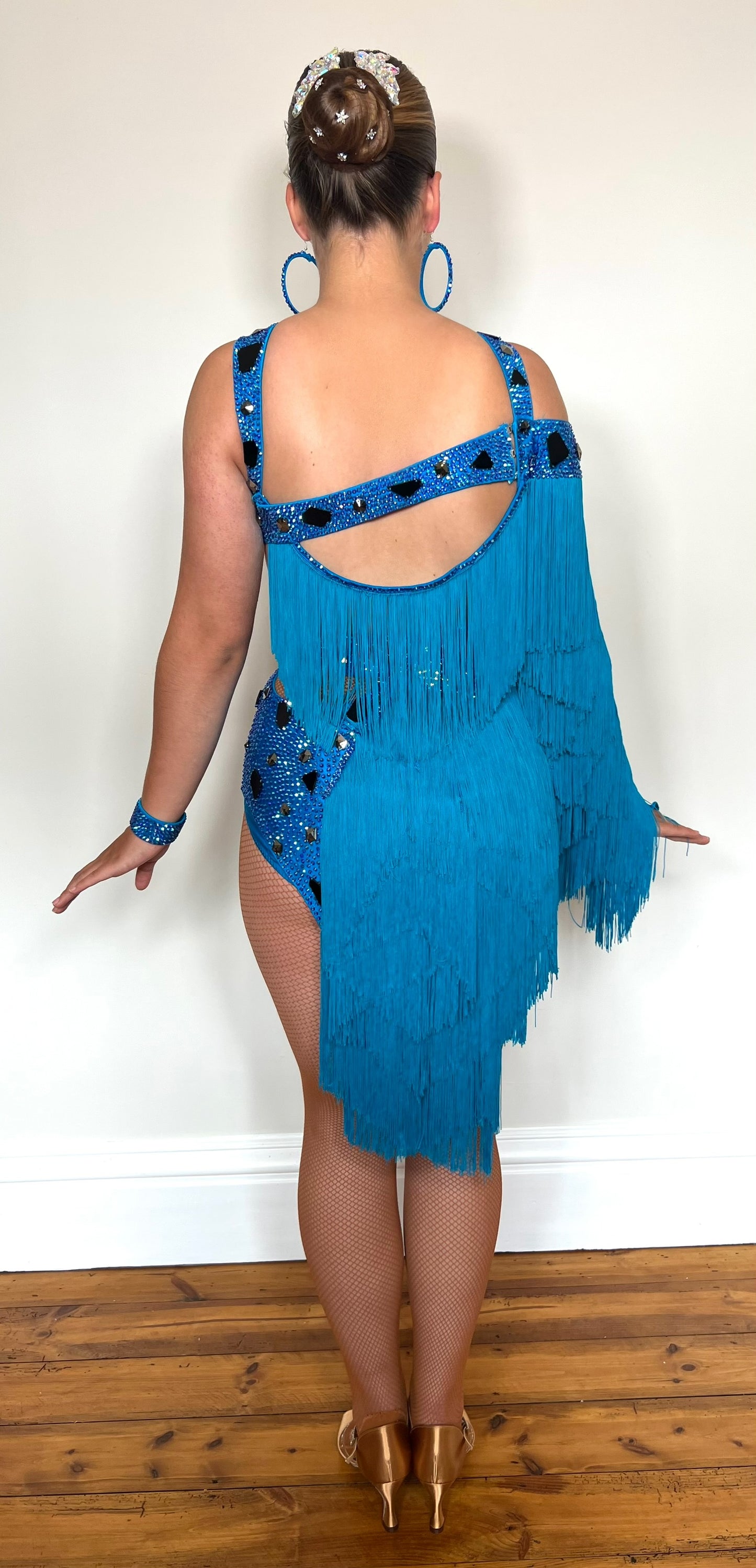 310 Statement Turquoise Latin Dress. Fringed one arm dress with strapping details decorated with Turquoise stones.