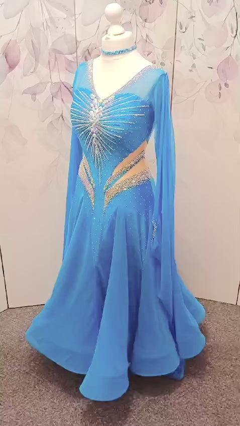 094 Turquoise Competition Ballroom Dance Dress heavily decorated heavily decorated with AB & Capri Blue Stones. Flattering stoned strap detailing detailing to the waist area. High back to give option to wear own bra. Detachable floats