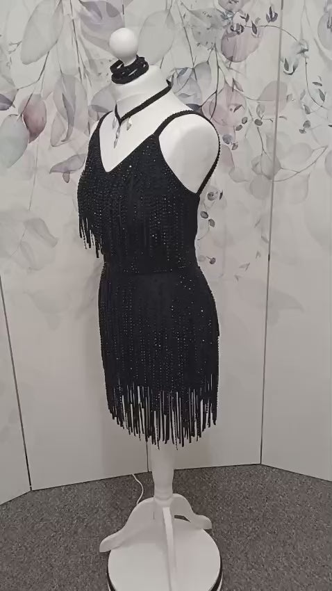 24L Black Latin/Rhythm Competition Dance Dress. Heavily stoned in Black with optional Belt. Stoned Fabric strips to the chest area and skirt. Cones with Necklace & Armbands